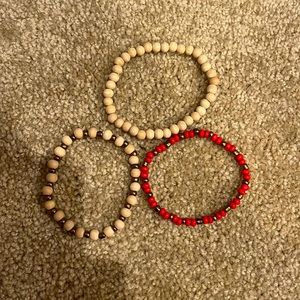 Two tan bracelets and one red braclet